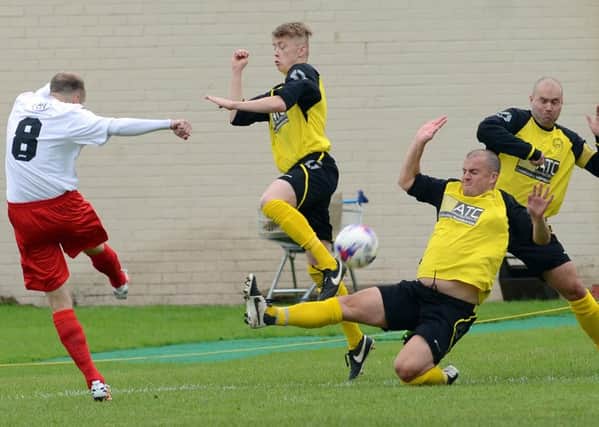Kirk Forbes fires a shot at goal as three Bellshill defenders try to block.