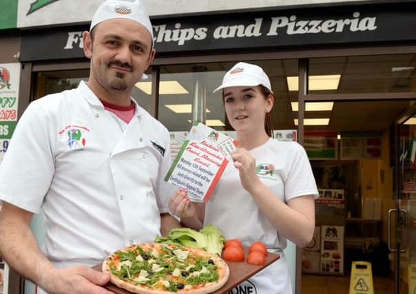 Fausto, with staff member Erin McGowan, hopes his charity pizzas go down well.