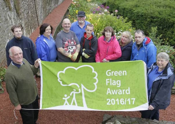 Castlebank volunteer 'gaffer' Ernest Romer (left) and Trust chairman Sylvia Russell (right) with some for the volunteer Friends of the Park show off the new Green Flag.