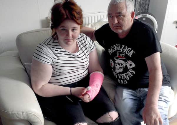 Nicolle O'Hara, nursing her broken wrist, with dad Anthony.