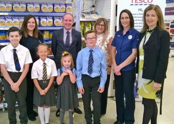 Tesco Extra Bellshill customer experience manager Ailsa Hume (third, right) and community champion Nadine Punder and Mossend and Holytown councillor Frank McNally with (l-r) Mossend Primary pupil Ross Stevenson, parent council chairwoman Andrea Gardner and pupil Kalyse Gardner, Holy Family Primary pupils Eva Norrie and Cain Dillon and head teacher Frances Wilson.