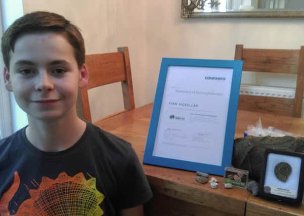 Budding palaeontologist Finn McKellar with his university certificate and fossil collection