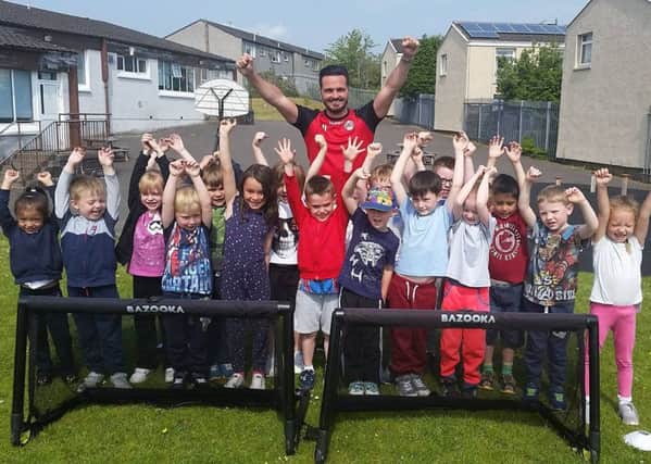New Carbon Clyde 'signing' Sean Higgins with pupils from St Lucy's Primary