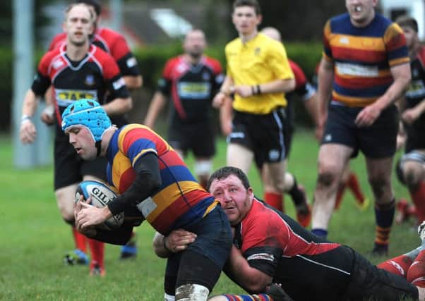 A Lenzie player is tackled by a Stewartry opponent