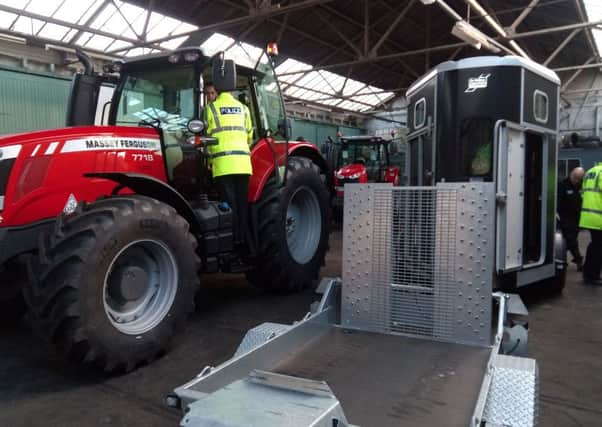 Police officers look for the identification marks on tractors and trailers in the shed at Ross of Lanark.