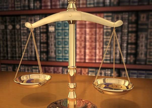 Brass Scales of Justice on a desk showing Depth-of-field books behind in the background
