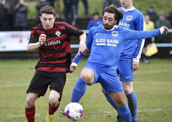 Luke Whelan battles for possession with a Cumnock player