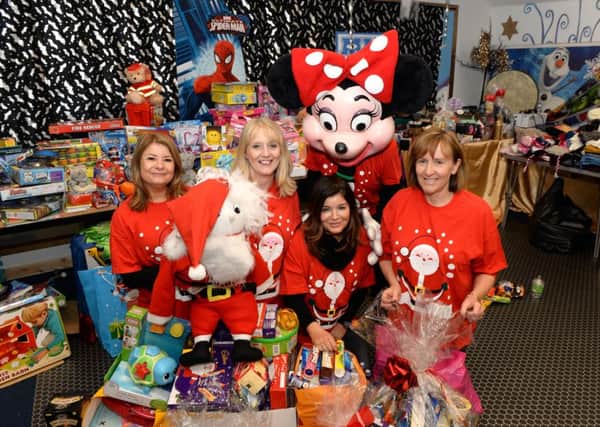 Minnie Mouse stopped by to help (l-r) Kim Milligan, Gail Gillon, Louise Dacre and Lesley Watson wrap Christmas presents.