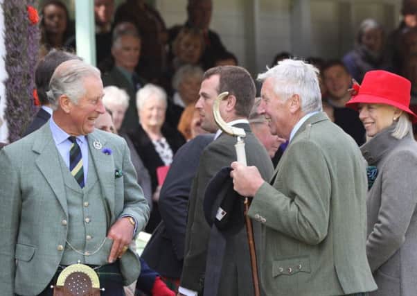 His Royal Highness Prince Charles, The Duke of Rothesay shares a joke with officials at the 2015 Braemar Gathering.