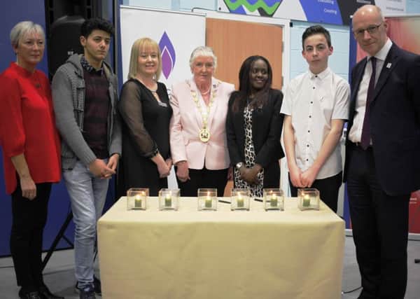 Memorial candle lighters at Holocaust Memorial Day event.