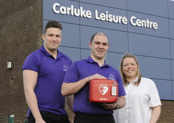 Steven Cochrane (left), Chris Markey (centre) and
Thomas Baxter (not pictured) carried out life-saving CPR  while Duty
Officer Fiona Miller operated the defibrillator at Carluke Leisure Centre.