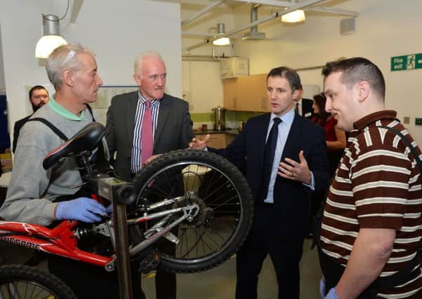 Justice Secretary Michael Matheson (second, right) learns how to refurbish a bike during his tour of the Restorative Justice facility in Bellshill