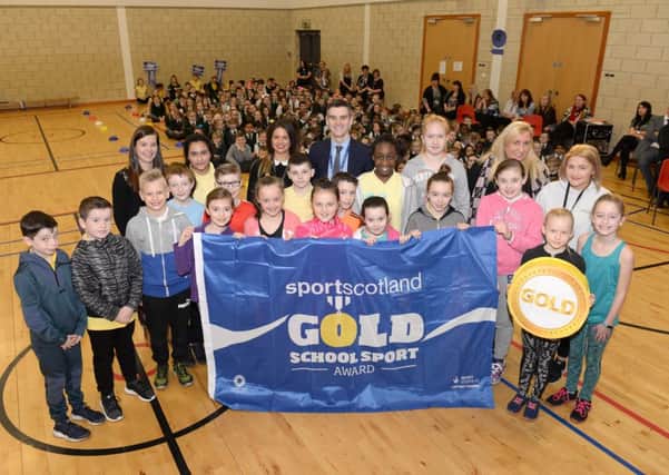 Cathedral Primary receive the gold flag from sportscotland's Robbie Stewart (back, centre)