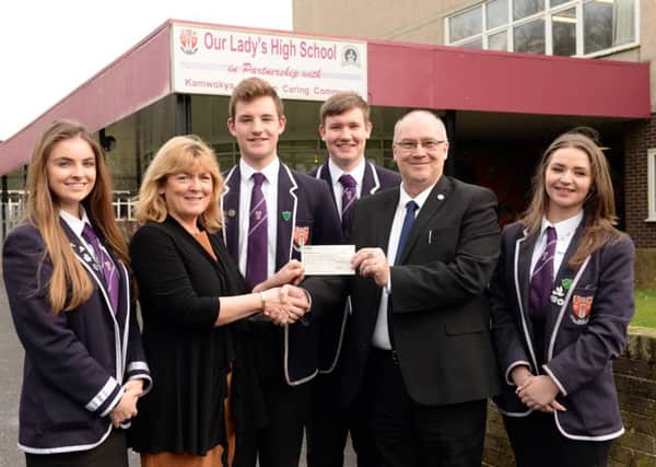 Head teacher Kathleen Sinclair accepts the cheque for Â£17,500 from Forgewood Holdings director/trustee Charlie Millar as, l-r, S6 pupils Niamh McDevitt, Adam Fallon, Craig Thomas and Morgan Campbell look on.