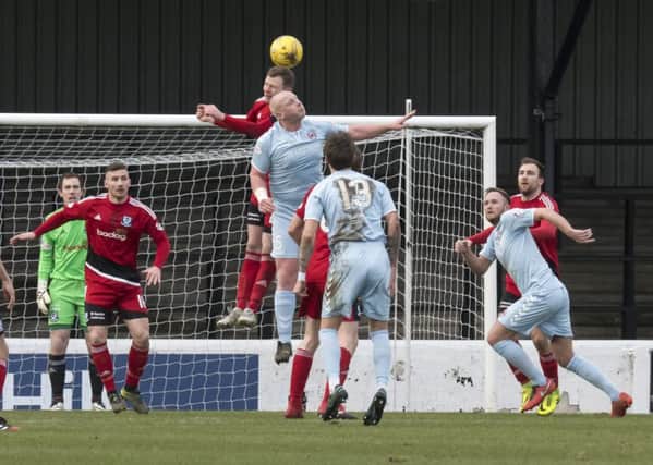 Chris Smith in an aerial battle as Clyde try to find a way through the Ayr defence (pic by Kevin Thorne)