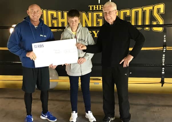 Fighting Scots Gym owner Frank Gilluley (left) and his father Frank present a cheque to Theresa Campbell