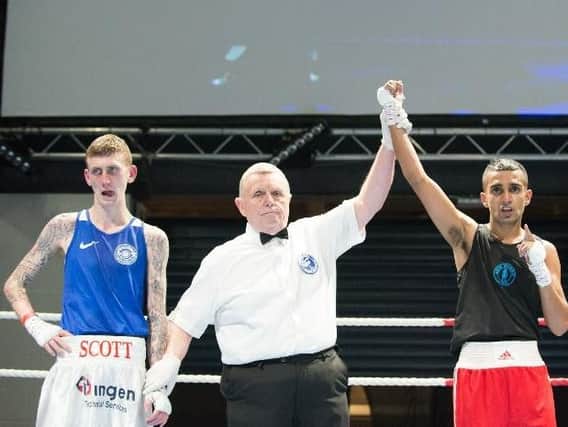 Aqeel Ahmed (right) has his arm raised aloft by the referee after winning the Scottish light flyweight crown