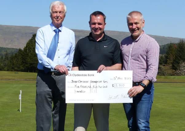 Stuart Neil (centre) and Hilton park captain Iain Murray (left) present a Â£5,500 cheque to Laurence Dunn (right)of the Neuro-Oncology Endowment Fund