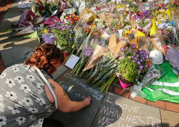 People lay flowers in Manchester to remember all those who were killed in Monday night's terror attack. Photo - SWNS