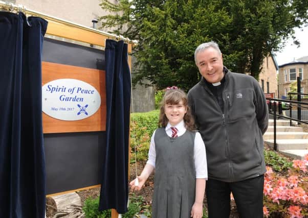 St Andrew's Church. Opening of new 'spirit of peace' garden. Evie Thomas P3 (7) with Father Makle.