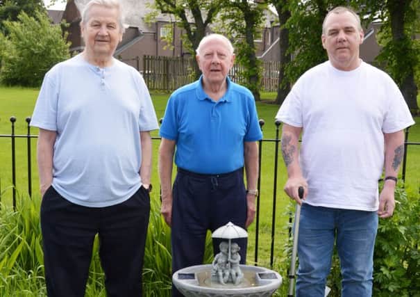 (l-r) Matt Muircroft, Bill Bulloch and David Muircroft with the new fountain in the Living well with Dementia garden