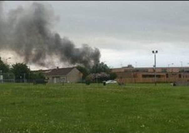 Smoke rises from the former school