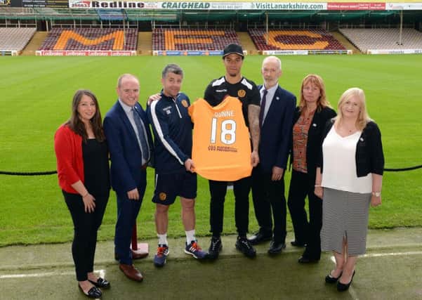 New signing Charles Dunne shows off his shirt, with team manager Steve Robinson and representatives of the anti-suicide campaign which Motherwell FC is backing for the second consecutive year
