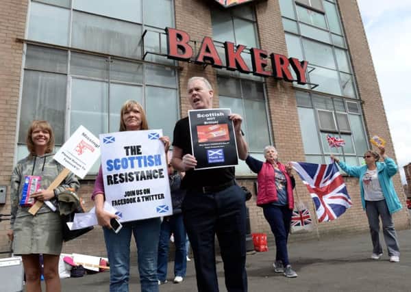 Members of the Scottish Resistance demonstrate at Tunnocks as a counter protest goes on behind them. Pic: Alan Watson