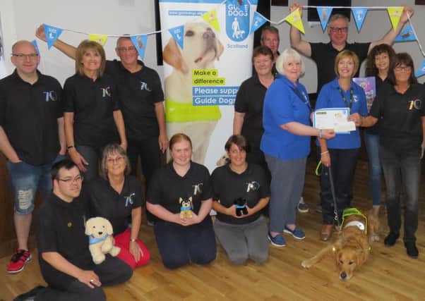 Easter Egg Cub president Moyra Scott presents a cheque for Â£1000 to the Guide Dogs charity on behalf of the club.