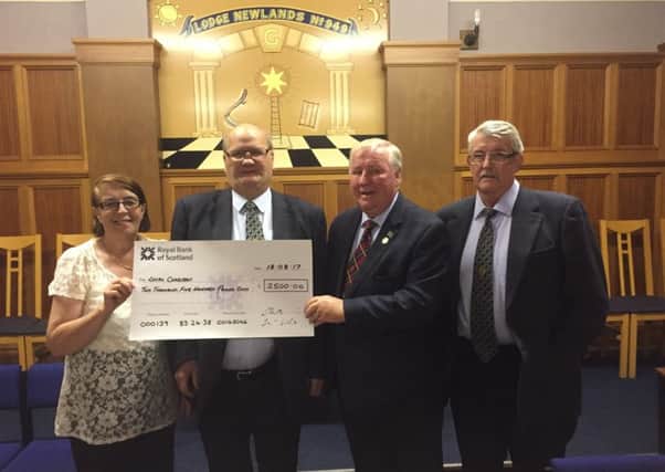 PGM Bro Alexander G Thomson (centre) along with PGL Almoner Bro Robin Jardine present cheques to Jim Forrest and Marie McCann.