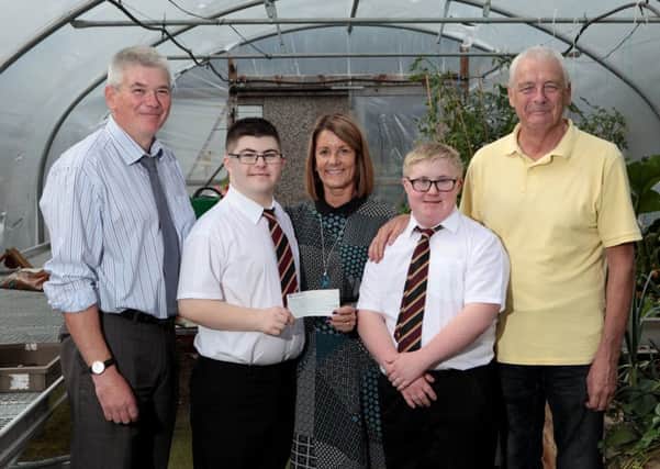 Pupils Cameron Docherty and Reece Cooper accept a cheque from Elaine MacDonald as head teacher John Morley, left, and ASN assistant Billy Gray look on