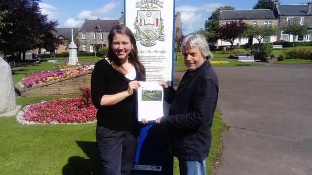 Aileen Campbell MSP with Tom Sneddon of the development trust, and her survey.