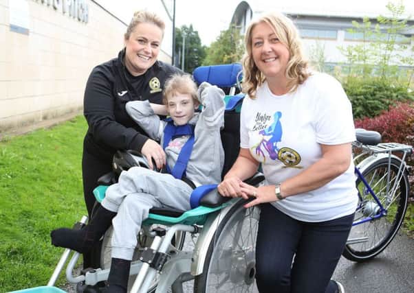 Faith from Victoria Park School tries the Blantyre Bikes Better wheelchair cycle with Lisa Mallin and Linda Riddoch. from Blantyre Soccer Academy.