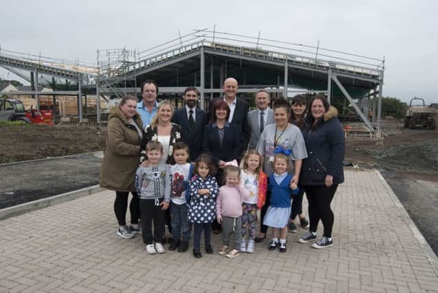 Councillors, council officers and children outside the new building