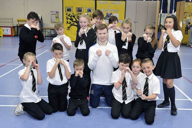 Pupils are pictured with Charlie learning how to defend themselves in the boxing ring.