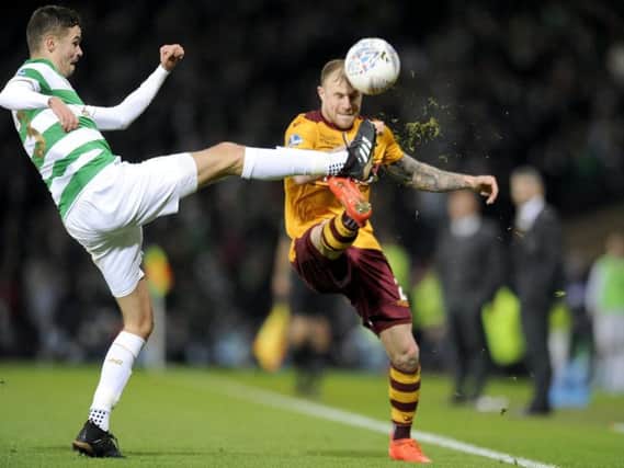 Motherwell defender Richard Tait goes in bravely against Celtic's Mikael Lustig during Sunday's Betfred Cup final. The pair will lock horns again at Fir Park tonight. (Pic by Michael Gillen)