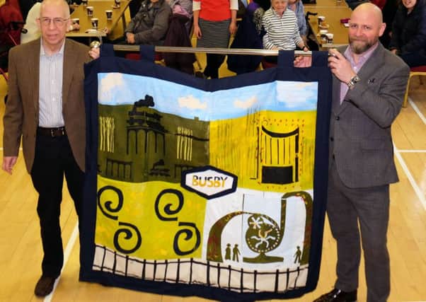 Busby resident Ostap Melnick (left) and ERCL chief executive, Anthony McReavy with the banner created by the Ebb and Flow project.