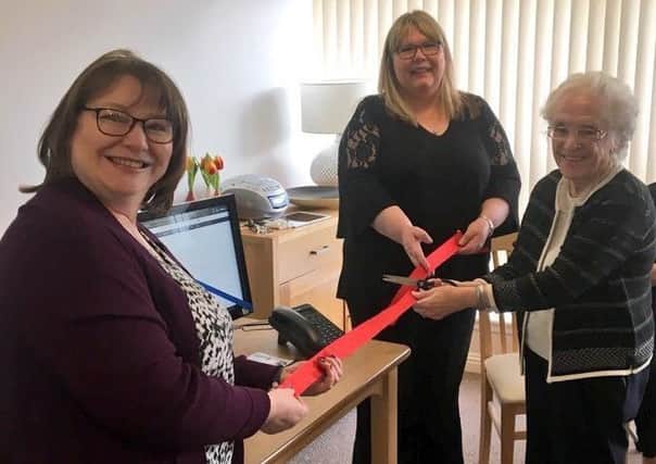 Clare Adamson MSP cutting the ribbon with Trust housing coordinator Tricia Djuritschek and Mission Place tenant May Dougan