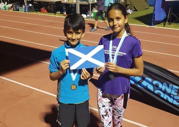 Mekaal and Zara Rahim show off the medals they won for completing the marathon in Canberra which was also the final leg of their globe-trotting challenge