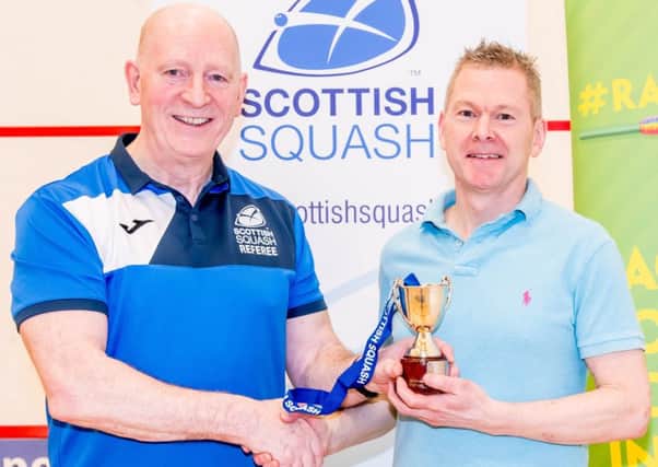 Lenzie's Brian Robertson (right) receives his trophy from Scottish Squash President Jim Hay (Photo: Paul J Roberts | RobertsSports Photo)