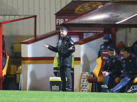 A soaked Stephen Robinson surveys the scene from the dugout at a saturated Fir Park on Tuesday night (Pic by Ian McFadyen)