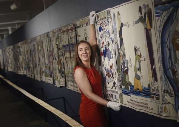 Marketing and PR Officer Melissa Reilly is pictured putting the finishing touches to the tapestry display.