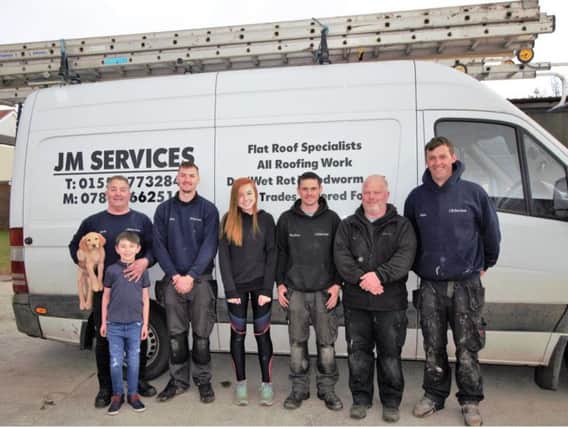 JM Services boss Jack Mellon (first left), his grandson Lewis and fellow staff members at the Carluke-based roofing busines were delighted to pose for this picture with athletics star Katie Foss (Submitted pic)