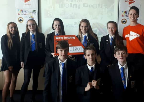 The fundraising group hand over their donation to a representative from the MS Society.