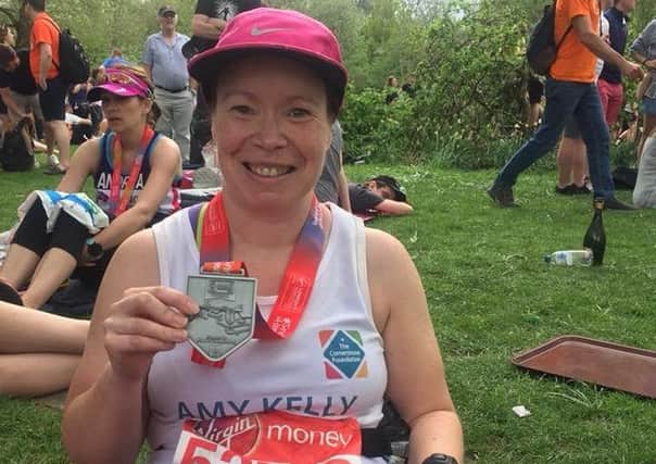 Amy is pictured with her medal after completing the London Marathon.