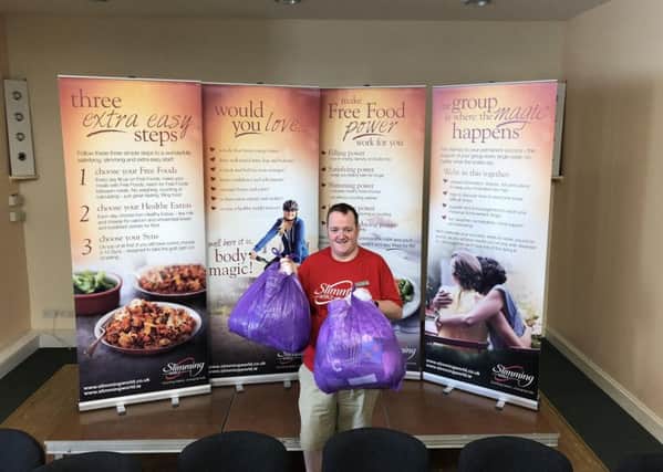 Rob Watson-Worlidge, who runs the Bellshill Sacred Heart Parish Hall Slimming World groups, with some of the bags collected as part of the Big Slimming World Clothes Throw