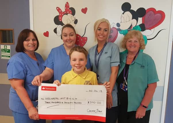 Eight-year-old Camron Barr is pictured presenting his cheque to staff at the neonatal unit.