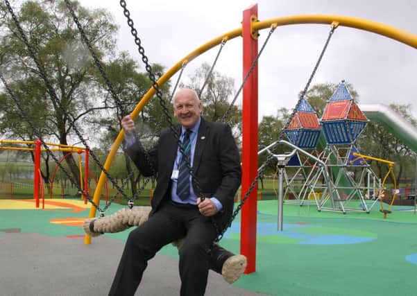 Councillor Alan Lafferty tries out the new play equipment at Cowan Park.