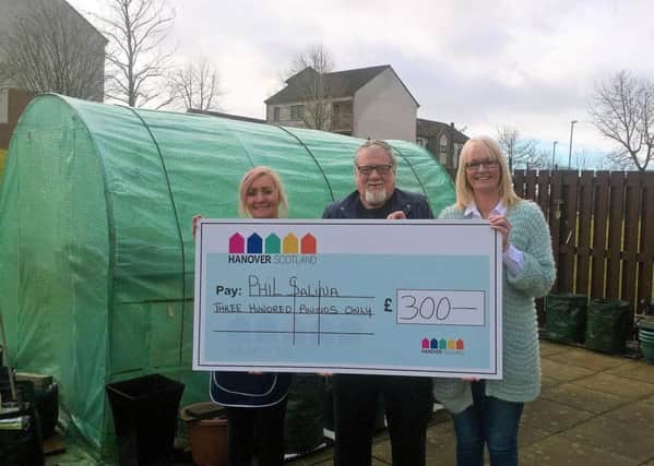 Phil Salina with development cleaner Maria Speirs (left) and development manager Sharon McLean as he gets the funds to continue his garden at Baillie Court