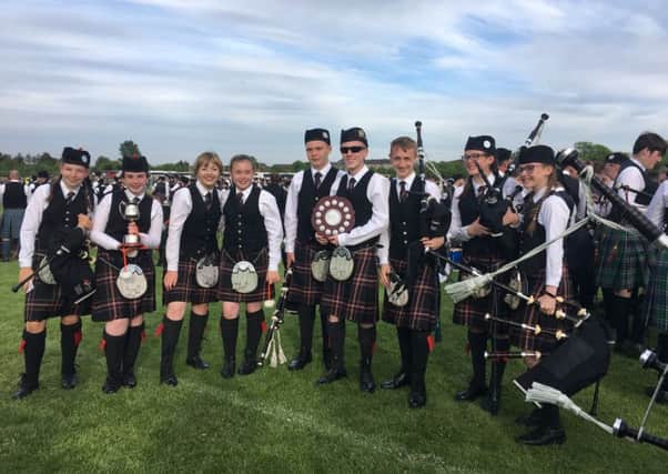 Members of North Lanarkshire Schools Pipe Band show off their silverware from a successful competition in Paisley
